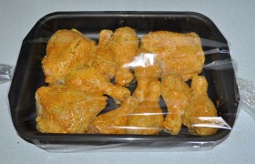 Размещать пакет с курицей в форме – не самое удобное занятие, так что мы поступаем проще: распределяем ножки и бедрышки в форме, еще разок смазываем маринадом. А на форму надеваем рукав. Края, как обычно, не стягиваем плотно - для выхода излишков пара.
