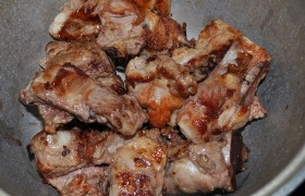 Маслу в сковороде на самом сильном огне даем  перекалиться , половину ребрышек быстро жарим до корочек, выкладываем в казан, так же жарим и оставшиеся ребрышки. Солим, перчим, добавляем томатное пюре или пасту, немного воды – и оставляем под крышкой тушиться на слабом огне. 