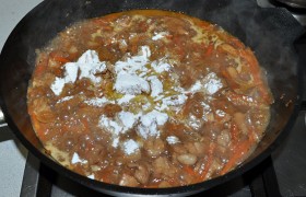 Пока соус с мясом закипает, рассыпаем крахмал через ситечко (это избавляет от комочков). Быстро перемешиваем, видим, как густеет соус. Посыпаем кунжутом.