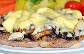 Запеченные свиные отбивные с грибами и сыром