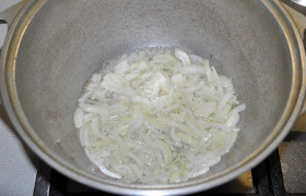 Пока латка или иная подходящая посуда раскаляется с маслом на сильном огне, мелко шинкуем лук. Засыпаем в латку, помешивая, пассеруем (обжариваем) 3-4 минуты, до мягкости.