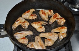 Разогреваем масло в сковороде, быстро обжариваем крылышки с обеих сторон до корочек.