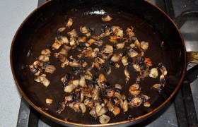 Пока в сковороде разогревается на достаточно сильном огне масло, нарезаем шампиньоны и за 5-6 минут обжариваем до готовности, перекладываем на тарелку для остывания.