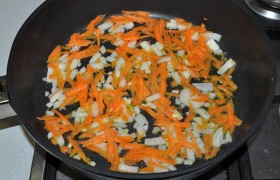 Для  заправки  супа рубим очищенную луковицу, натираем морковь. Тут уже разогрелась сковорода с маслом на среднем огне, засыпаем овощи,  пассеруем  5- 6 минут, иногда помешивая.