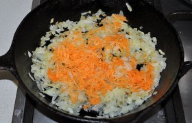 Натираем крупно морковь и добавляем к луку, обжариваем еще 3-4 минуты.