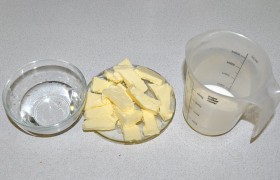 Все необходимое – молоко, нарезанное для быстрого размягчения масло, воду – ставим поближе к варочной панели. Если собираемся добавить в сыр наполнители – подготавливаем тоже.