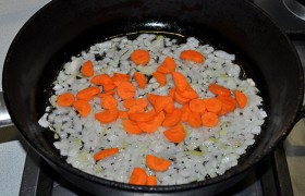 Для заправки борща мелко нарезаем лук, пассеруем его в сковороде на среднем огне не менее 6-7 минут, до мягкости, помешиваем. Добавляем нарезанную или тертую морковь, продолжаем обжаривать еще 5 минут.