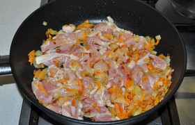 Перекладываем в сковороду к овощам, часто помешивая, обжариваем 5-7 минут – пока все мясные кусочки станут светлыми.