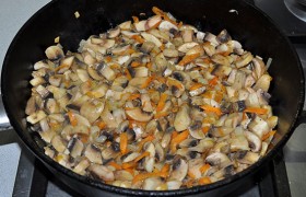 В сковороду добавляем сливочное масло. Грибы протираем влажной салфеткой, нарезаем и обжариваем вместе с овощами 4-5 минут.