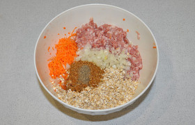 Выкладываем в миску фарш, добавляем хлопья геркулеса, мелко порубленный лук, морковь, натертую на самой мелкой терке. Плюс соль и перец.
