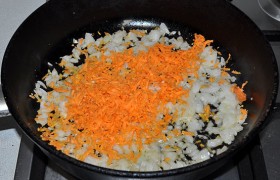 Чистим, натираем и добавляем к луку морковь, продолжаем обжаривание еще столько же.
