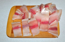Поскольку рыбу мы обычно покупаем замороженную, то даем ей естественным образом разморозиться. Тщательно промываем рыбу. И хорошо отжимаем филе, не жалея бумажных полотенец. Нарезаем немелкими кусочками, примерно 5 см ширины.