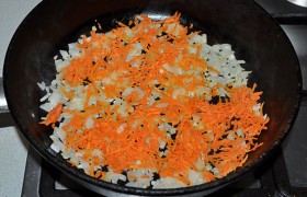 Добавляем тертую морковь и продолжаем медленное обжаривание еще 5-6 минут.