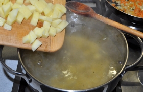 Картофель засыпаем в кипящую в кастрюле воду, кладем лавровый лист, горошки перца, немного солим, оставляем вариться на слабом огне в закрытой кастрюле.