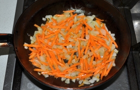Лук шинкуем. На среднем огне 5-6 минут  пассеруем  его, затем добавляем тертую морковь, продолжаем пассеровку еще 4-5 минут. И еще 5 минут тушим овощи, добавив немного кипятка из кастрюли с бульоном.