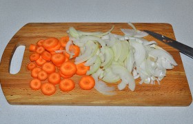 Нарезаем обе луковицы полукольцами, морковь – кружками, но можем натереть, посыпаем щепоткой соли.