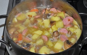 Перекладываем всё со сковороды в кастрюлю, где на слабом огне тушится картофель. Приправляем солью, лавровым листом и перцем, перемешиваем.