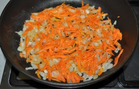 Шинкуем мелком кубиком луковицу, нарезаем или трем на терке морковь. Всыпаем в сковороду, в которой уже разогрелось масло.  Пассеруем  – на огне не больше среднего – овощи 6-7 минут, помешиваем временами. 