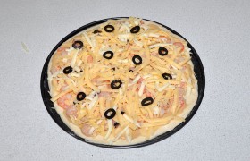 Посыпаем сыром и нарезанными маслинами (их можно и побольше положить). В разогретой до 210-220° духовке выпекаем пиццу до готовности – около 10 минут.