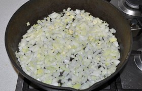 А пока шинкуем средним кубиком луковицы, измельчаем чеснок, масло разогреваем в толстодонной сковороде и на среднем огне, помешивая,  пассеруем  лук и чеснок 5-6 минут, до прозрачности лука.