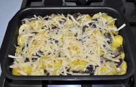 В духовке при 190-200° запекаем блюдо 35-40 минут. Когда картофель практически готов, добавляем тертый сыр. 