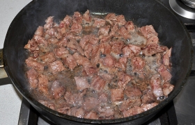 В толстодонную сковороду наливаем масло, оно  перекаливается  на сильном огне.за 4-5 минут. Закладываем кусочки мяса и обжариваем 2-3 минуты, перемешивая. Все мясо стало светлым – перекладываем его в тарелку.