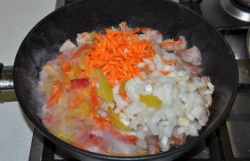 Добавляем в сковороду к мясу тонко тертую морковь, сладкий перец и вторую мелко порезанную луковицу. Перемешиваем, доводим до кипения, тушим 12-15 минут, если надо – подливаем немного кипятка.