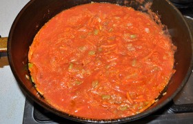 Когда лук стал мягким и прозрачным, добавляем измельченные в блендере помидоры. Тушим 5 минут в открытой сковороде.