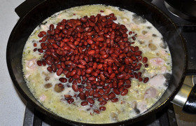 В сковороду с мясом закладываем фасоль. При желании можно положить несколько консервированных томатов. Вливаем вино.

