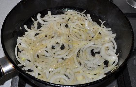А в сковороде 4-5 минут обжариваем до мягкости полукольца лука, в конце добавляем чеснок, жарим еще около минуты.