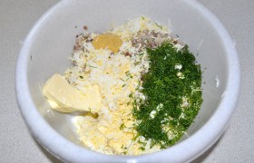 В миску, где уже размягчилось заранее нарезанное сливочное масло, добавляем селедку, натертое на мелкой терке яйцо, горчицу и рубленый укроп. 