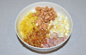 Собираем в миске все ингредиенты: картошку, яйца, обжаренный лук, куриное копченое мясо, белую фасоль. Посыпаем зеленью.