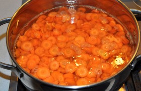 В кипящую в кастрюле воду закладываем подготовленную морковь, после нового закипания бланшируем ее 5 минут. Сливаем воду, подставив миску под дуршлаг. Плотно заполняем морковью банки.