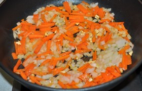 Так же тоненько шинкуем морковку, мелким кубиком – лук. На второй сковороде – и тоже на среднем огне – пассеруем корнеплоды 8-9 минут, добавляем натертые, без шкурки, помидоры, тушим в открытой сковороде 5-6 минут, выключаем  заправку . 
