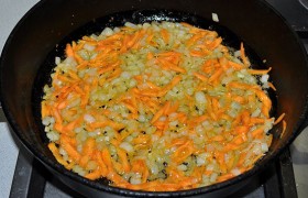 Шинкуем кубиками луковицу и натираем морковь. Когда сковорода с маслом разогрета на среднем огне, засыпаем лук и  пассеруем  5-6 минут, помешиваем. Добавляем морковь и обжариваем еще 4-5 минут.