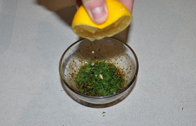 За несколько минут перед окончанием запекания добавляем в маринад зелень и выжимаем из половинки лимона сок.