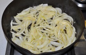 А пока нарезаем лук – перьями по вертикали, В сковороде разогреваем масло, кладем лук и пассеруем, помешивая, 5-6 минут.