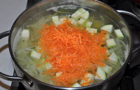 Нарезаем кубиком и кабачок. Морковь натираем или нарезаем – как нравится. Как раз время: опускаем ее в суп. И засыпаем кабачок.
