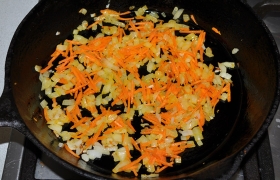 Минут через 20-30 начинаем готовить заправку супа.  Пассеруем  7-8 минут мелко нарезанные лук и морковь, помешиваем. Делаем это на среднем огне. Если любите в заправке сельдерей – обязательно положите.