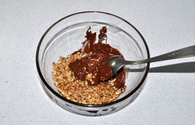 Ломаем плитку шоколада и расплавляем его в микроволновке. Соединяем с орехами, сухим молоком, вымешиваем, получается довольно густая кашица.