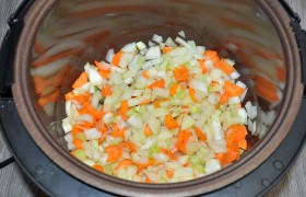 Разогретую мультиварку ставим на режим жарки, загружаем в нее морковь с луком и сельдерееем, периодически помешиваем, пока овощи потихоньку  пассеруются .