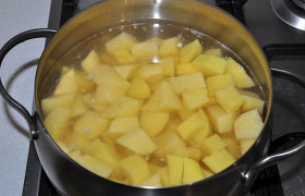 Начищенную картошку нарезаем, заливаем водой и ставим варить на конфорку.