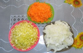 Между тем подготавливаем другие ингредиенты:  тонкой соломкой нарезаем промытые, очищенные от семян перцы, шинкуем лук и натираем морковку.
