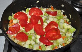 Нарезаем нетолстыми дольками помидор и добавляем в сковороду.