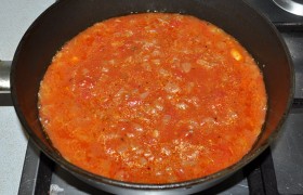 Шинкуем мелко и вторую луковицу,  пассеруем  в масле на среднем огне 6-7 минут, добавляем пюрированные консервированные или натертые свежие томаты, томатную пасту, сахар, понемногу соли и перца, 120-150 мл кипятка. Тушится соус минуты 4-6.