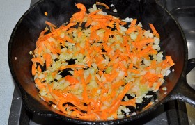 Когда бульон сварен, готовим  заправку  для щей. В сковороде на средне-сильном огне обжариваем нашинкованный лук, непрерывно помешивая. И еще 3 минуты обжариваем морковь вместе с луком.