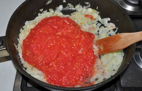 Всю томатную массу добавляем в сковороду с луком, после закипания на малом огне тушим 4-5 минут.